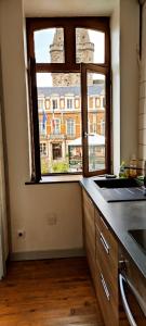 a kitchen with a view of a building from a window at Le Godefroy de Bouillon in Boulogne-sur-Mer