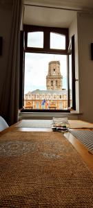 a bedroom with a window with a clock tower at Le Godefroy de Bouillon in Boulogne-sur-Mer