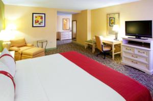 Holiday Inn Chantilly-Dulles Expo Airport, an IHG Hotel في شانتيلي: غرفة الفندق بسرير كبير ومكتب