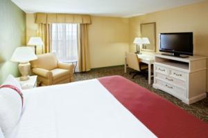 Holiday Inn Chantilly-Dulles Expo Airport, an IHG Hotel في شانتيلي: غرفه فندقيه سرير كبير وتلفزيون