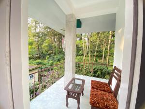 a view from the balcony of a house with a bench at Ammus Homestay in Thekkady