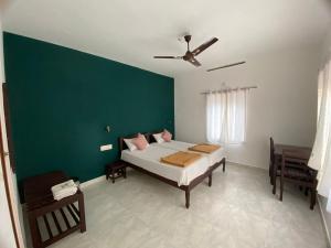 a bedroom with a bed and a green wall at Ammus Homestay in Thekkady