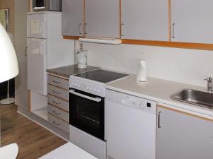 - une cuisine blanche avec cuisinière et évier dans l'établissement 6 person holiday home in Aabenraa, à Åbenrå