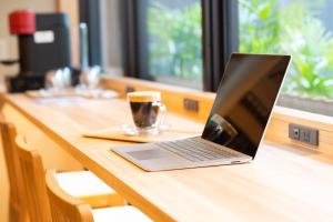 un ordinateur portable assis au-dessus d'une table en bois dans l'établissement Hotel Sugicho, à Kyoto