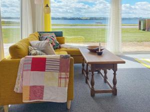 a living room with a yellow couch and a table at Holiday home Aabenraa LXIII in Aabenraa