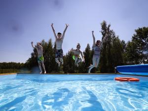 un groupe de personnes sautant dans une piscine dans l'établissement Moje Miejsce Kazimierz, à Kazimierz Dolny