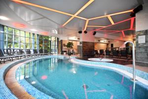 - une piscine dans une chambre d'hôtel entourée de chaises dans l'établissement Hotel Eger & Park, à Eger