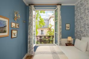 1 dormitorio con cama y ventana en Hotel des Grandes Ecoles, en París