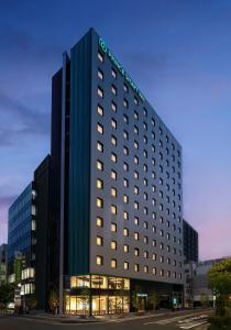 un edificio alto con un letrero iluminado en Prince Smart Inn Hakata, en Fukuoka