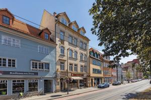 a street in a city with buildings and cars at Hotel Garni " Am Domplatz" in Erfurt