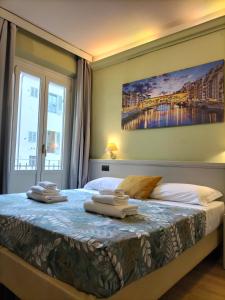 1 dormitorio con 1 cama con toallas en Hotel Camilla Firenze, en Florencia