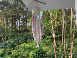 a dream catcher hanging in a forest at Ammus Homestay in Thekkady