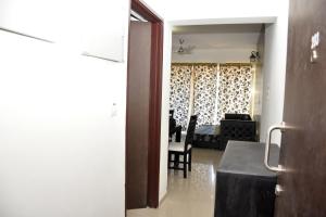 uma vista para uma sala de estar com uma mesa e cadeiras em 2BHK Lake View Apartment em Lavasa