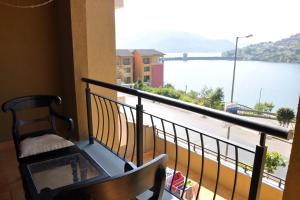 uma varanda com um banco e vista para a água em 2BHK Lake View Apartment em Lavasa