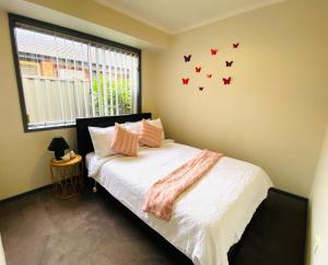 a bedroom with a bed with butterflies on the wall at ENTIRE HOME IN WERRIBEE,BEST POSSIBLE LOCATION YOU CAN FIND in Werribee