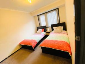 two beds in a room with a window at ENTIRE HOME IN WERRIBEE,BEST POSSIBLE LOCATION YOU CAN FIND in Werribee