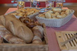 une table avec des paniers de différents types de pain dans l'établissement Berghaus Niederhorn, à Beatenberg