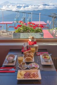 une table avec des assiettes de nourriture sur un balcon dans l'établissement Berghaus Niederhorn, à Beatenberg