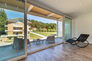 uma sala de estar aberta com portas de vidro deslizantes e um pátio em Promenaden-Strandhotel Marolt Haupthaus em Sankt Kanzian