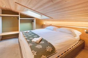 een groot bed in een kamer met een houten plafond bij Aria di Casa Reit in Valdisotto