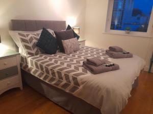 een slaapkamer met een groot bed en 2 handdoeken bij Fistral beach apartment in Newquay