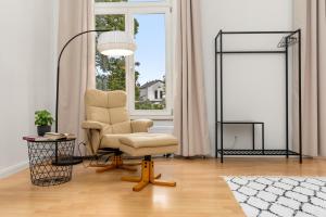 a living room with a chair and a lamp at HOMEY Apartments - Riverside - mit Weserblick und Parkplatz in Bremen