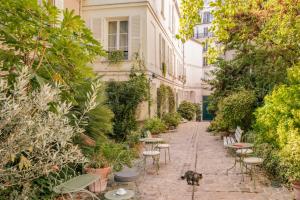 un perro caminando por una acera con mesas y sillas en Hotel des Grandes Ecoles, en París