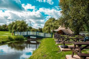 grupa stołów piknikowych i most nad rzeką w obiekcie The George Inn w mieście Warminster