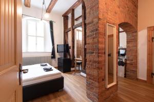 een kamer met een bakstenen muur en een kamer met een bed bij Ferienwohnung Venus in Quedlinburg