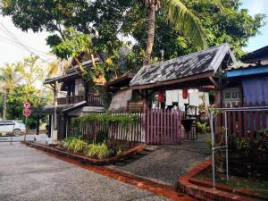 une maison avec une clôture devant elle dans l'établissement Khonesavane Hostel, à Luang Prabang