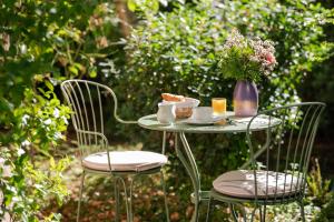 una mesa con una taza de té y un jarrón de flores en Hotel des Grandes Ecoles, en París