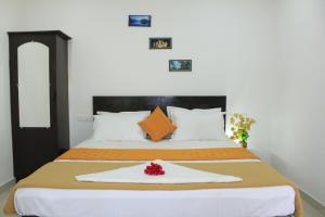 pokój hotelowy z łóżkiem z czerwonym kwiatem w obiekcie SpiceGreen Homestay,Thekkady w mieście Thekkady