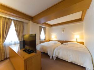 um quarto de hotel com duas camas e uma televisão de ecrã plano em Hotel Matsunoka Ichinoseki em Ichinoseki