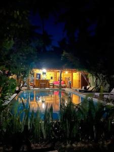 a swimming pool in front of a house at night at Villa Jati Mangsit in Senggigi 