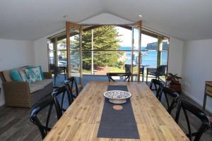 - une table en bois dans une chambre avec vue sur l'océan dans l'établissement 12 Rocks Beach View Loft Central Port Campbell, à Port Campbell