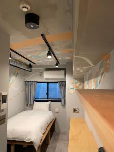 Kleines Zimmer mit einem Bett und einem Schreibtisch. in der Unterkunft ART HOTELS SHIBUYA in Tokio