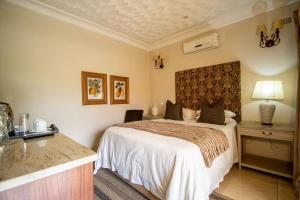 The Victoria Falls Deluxe Suites में एक कमरे में एक या कई बेड