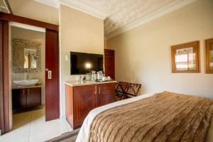 The Victoria Falls Deluxe Suites में एक कमरे में एक या कई बेड