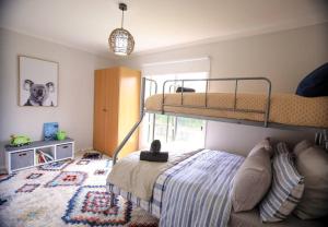 ein Schlafzimmer mit einem Etagenbett und einem Sofa in der Unterkunft The Hangout KING BEDS Hammock Chairs with a View in Port Campbell