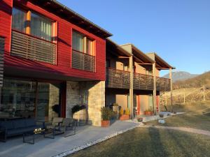 a red building with chairs in front of it at Agritur Verderame in Trento