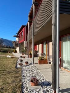 a patio with potted plants on the side of a building at Agritur Verderame in Trento