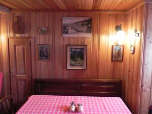 a bedroom with a table with a pink checkered table cloth at Le Vieux Rascard Chambres d'Hotes in Champoluc