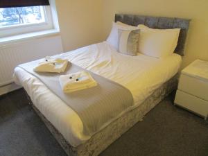 a bedroom with a bed with two towels on it at The New Alexandra Hotel in Llandudno