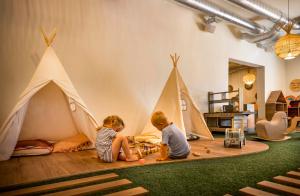 two children playing with toy tents in a room at Valamar Amicor Resort in Stari Grad