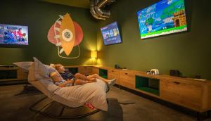 two children sitting in a chair in a room with a tv at Valamar Amicor Resort in Stari Grad