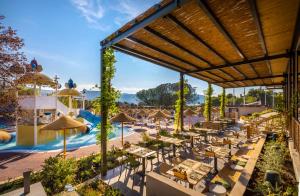 an outdoor patio with tables and umbrellas at a resort at Valamar Amicor Resort in Stari Grad