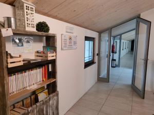 a hallway with a book shelf with books at La Corte Room & Relax in Rovereto