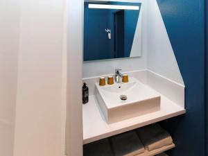 y baño con lavabo blanco y espejo. en ibis Budget La Teste Bassin d'Arcachon, en La Teste-de-Buch