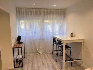 um quarto com uma mesa e dois bancos em frente a uma janela em Charmant appartement 2 pièces em Valence