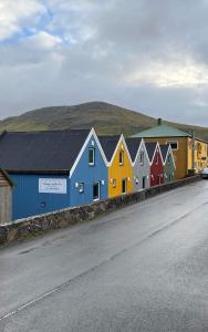 uma fila de casas coloridas no lado de uma estrada em Cottages by the Sea em Sørvágur